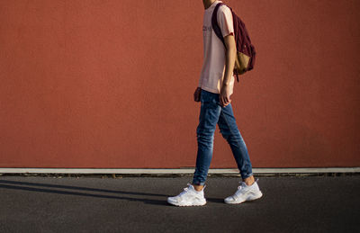 Low section of woman standing against wall