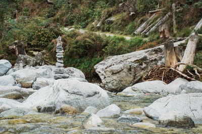 Stone wall by rocks in forest