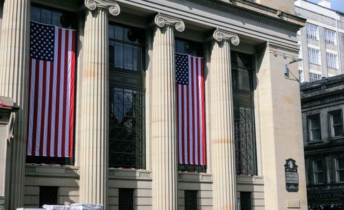 Low angle view of flags against buildings in city