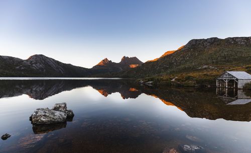Reflection of mountains in lake against clear sky