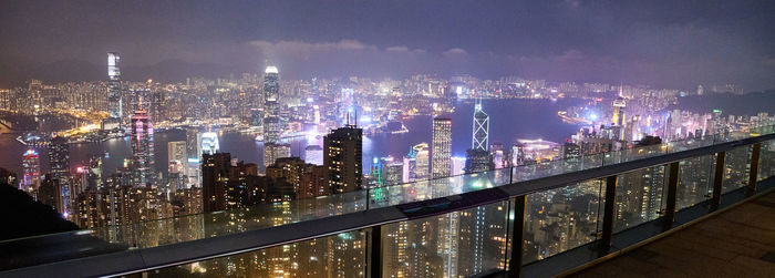 Illuminated buildings in city against sky at night