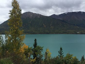 Scenic view of lake by mountains against sky