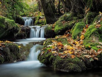 Long-exposure of river with cascades in autumn