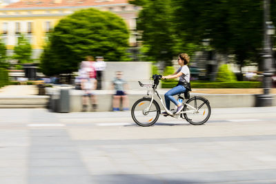 Man riding bicycle on road in city