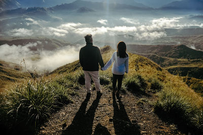 Rear view of people on landscape against sky