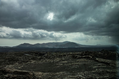 Scenic view of landscape against storm clouds