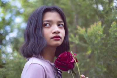 Portrait of beautiful woman with red flower