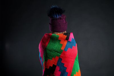 Rear view of multi colored umbrellas against black background