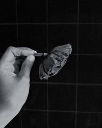 Midsection of man holding umbrella on tiled floor