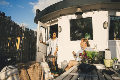 Man looking at woman standing on doorway of houseboat