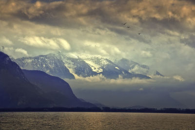 Idyllic shot of lake geneva and mountains against cloudy sky