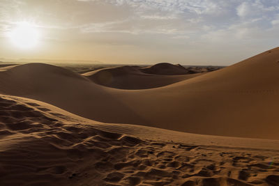 Scenic view of desert against sky during sunset