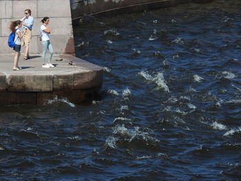 Rear view of people standing in sea