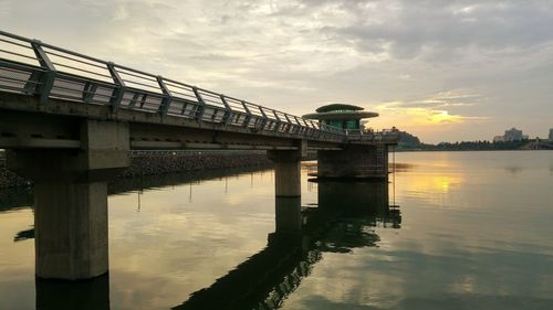 Bridge over river against cloudy sky