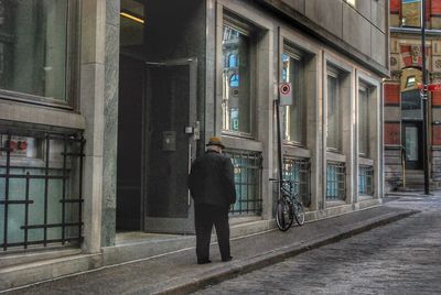 Rear view of woman walking on road in city