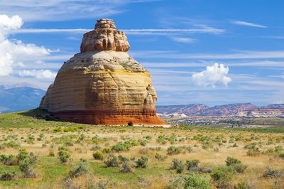 Church rock formations on landscape against cloudy sky