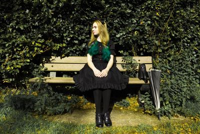 Young woman standing against wall