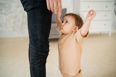 Low section of woman standing against wall