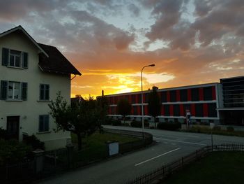 Houses against dramatic sky during sunset