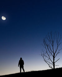 Silhouette men on field against sky at night