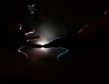 Close-up of silhouette hand on black background