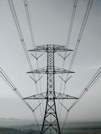 Low angle view of electricity pylon against sky