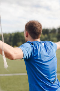 Rear view of man playing on field