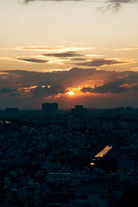 High angle view of silhouette buildings against sky during sunset