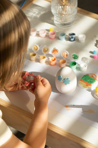 Cropped hands of girl playing with toys on table