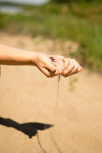 Midsection of person hand on sand