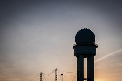 Low angle view of silhouette tower and building against sky