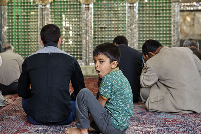 Rear view of people sitting on floor