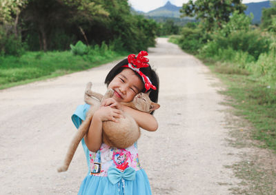 Side view of young girl drinking water while standing on field