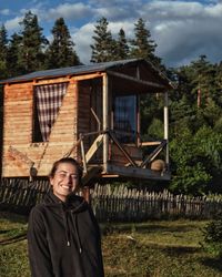 Portrait of smiling woman standing against trees