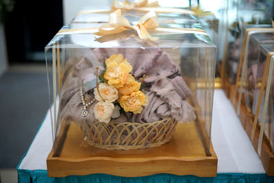 Close-up of food and wedding gift in glass box on table