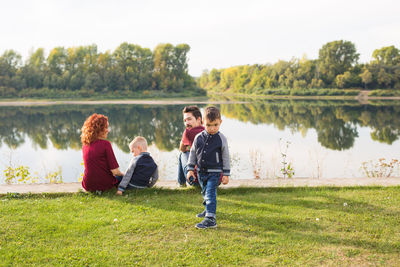 Rear view of people enjoying in lake