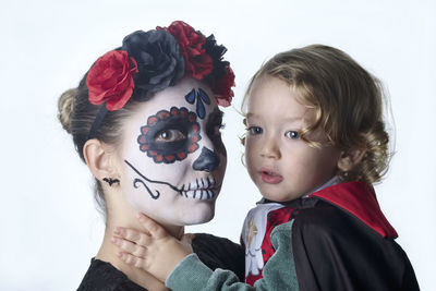 Close-up portrait of woman and girl over white background