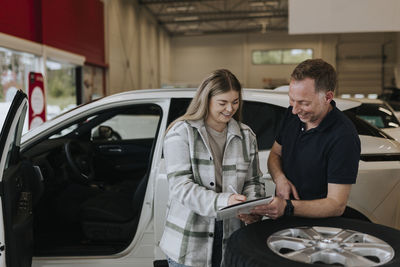 Woman signing contract in car dealership