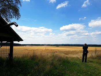 Man standing on field against sky