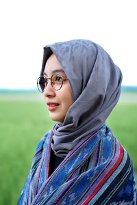 Portrait of smiling young woman wearing mask on field