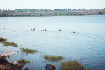 People in lake against sky