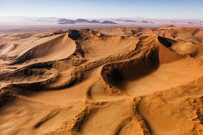 Panoramic view of sand dunes in desert against sky