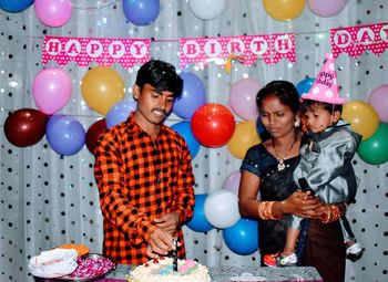 Two people with balloons at home