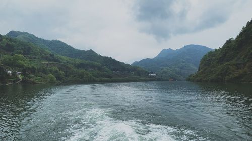 Scenic view of river and mountains against sky