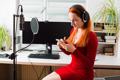 Side view of woman sitting in recording studio