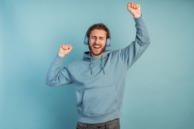 Portrait of smiling man standing against blue background