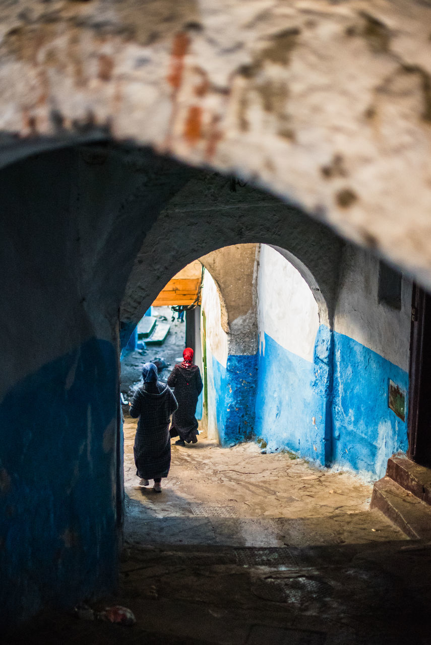 REAR VIEW OF PEOPLE WALKING ON BUILDING