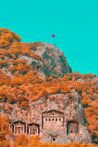 Low angle view of flag on mountain against sky