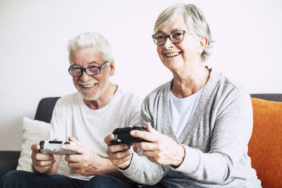 Smiling senior couple playing video game at home