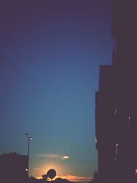 Low angle view of illuminated street light against sky at dusk